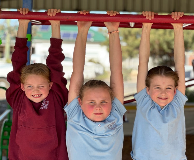 Three girls hanging on mokney bars