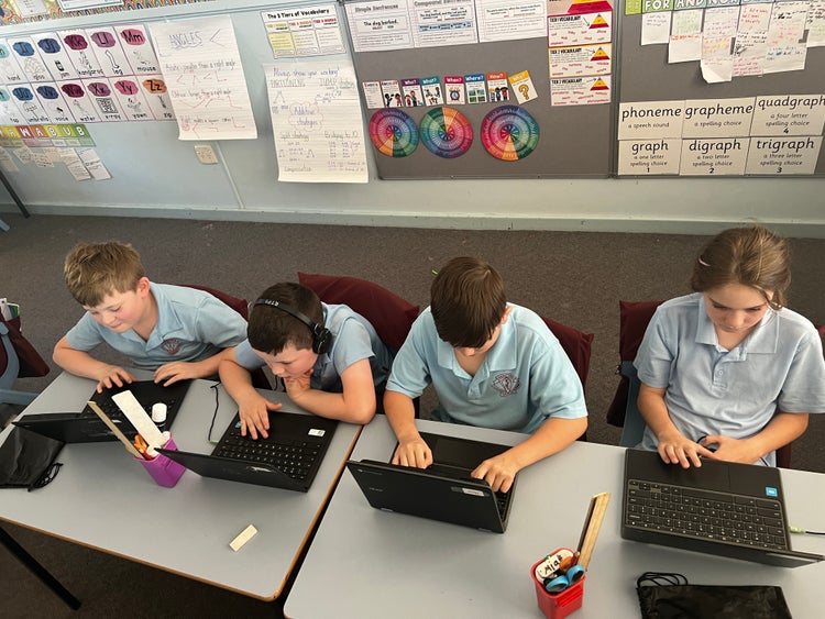 Four students working on Chrome books