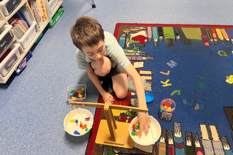 Boy using balancing scale to measure weight