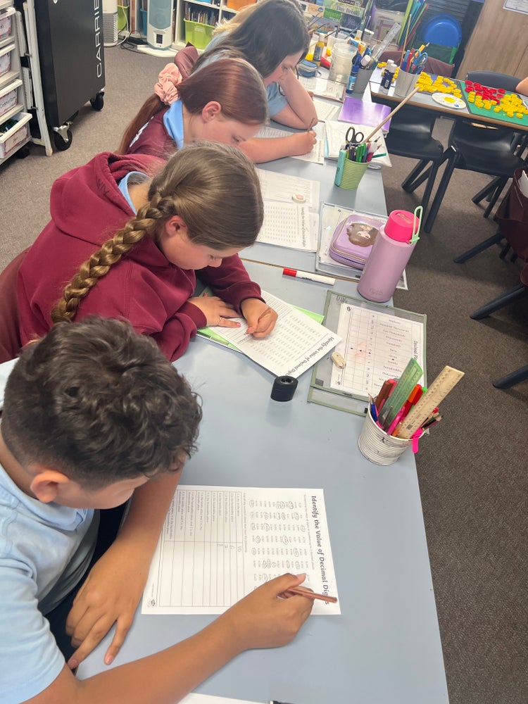 Four students completing work at their desk