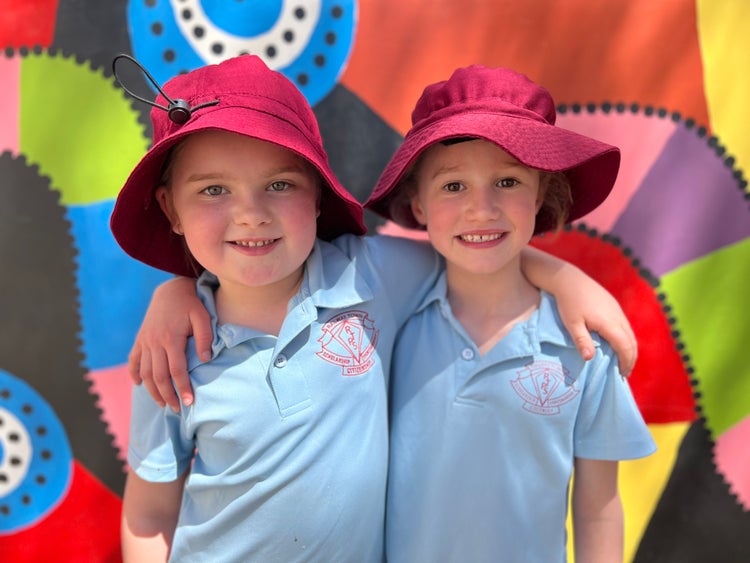 Girls with arms around shoulders in playground