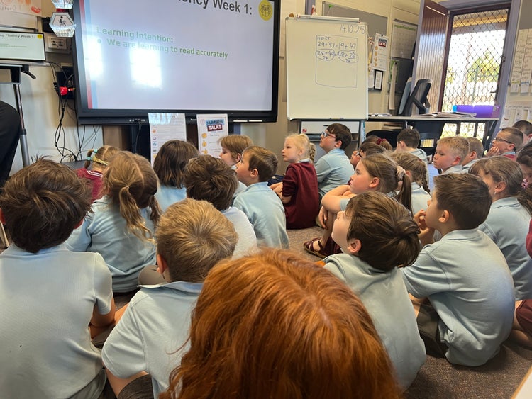 Students sitting on floor in classroom