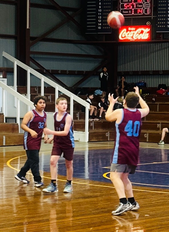 Three boys in basketball team playing on court