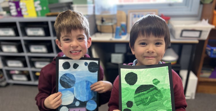 Two kinder boys holding their artworks