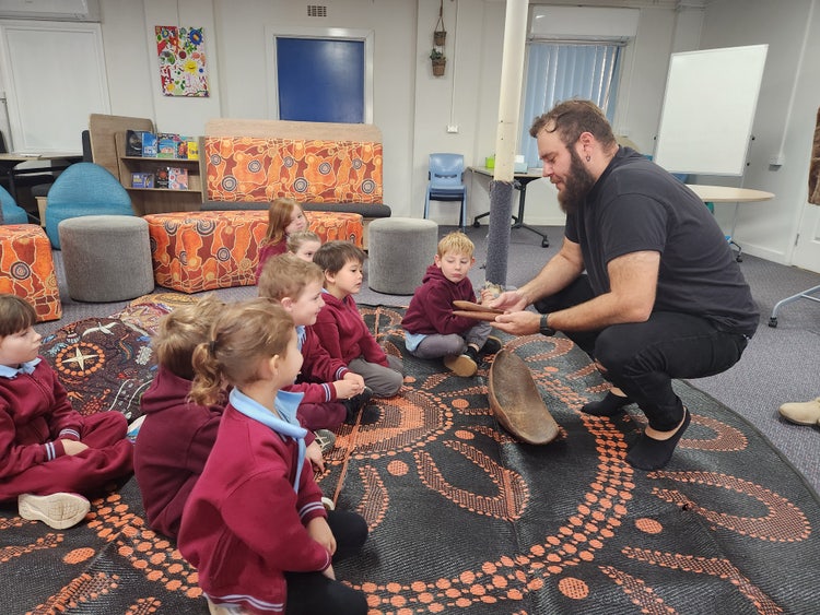 Kinder class in language room looking at clap sticks