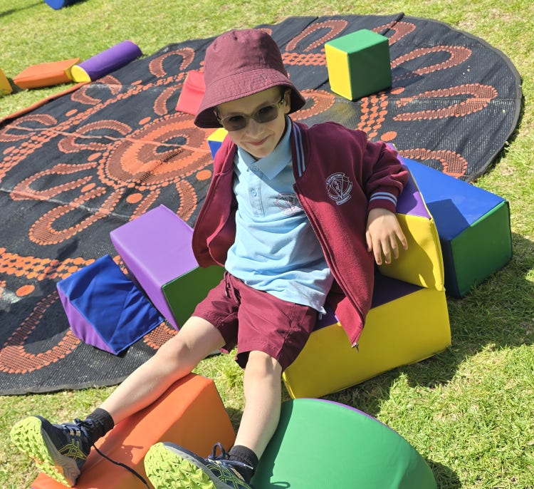 Infants boy sitting on foam blocks on grass