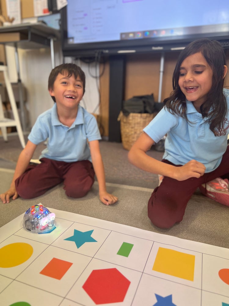Boy and girl playing with bee bot