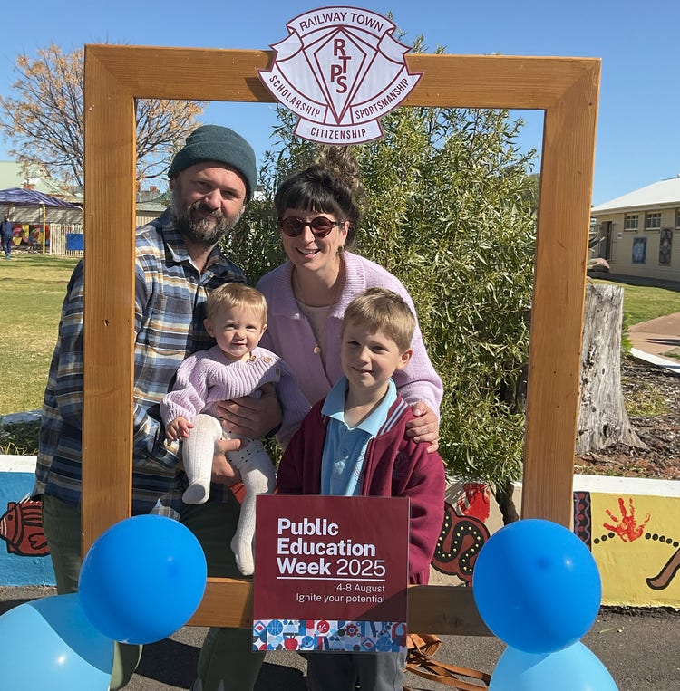 Family standing behind Education Week frame