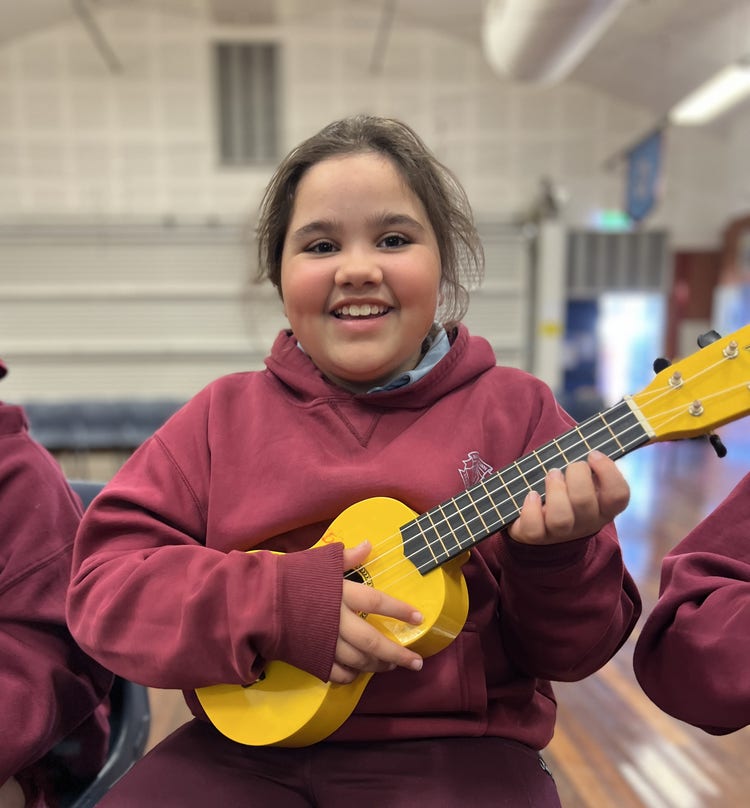 Primary girl playing ukulele