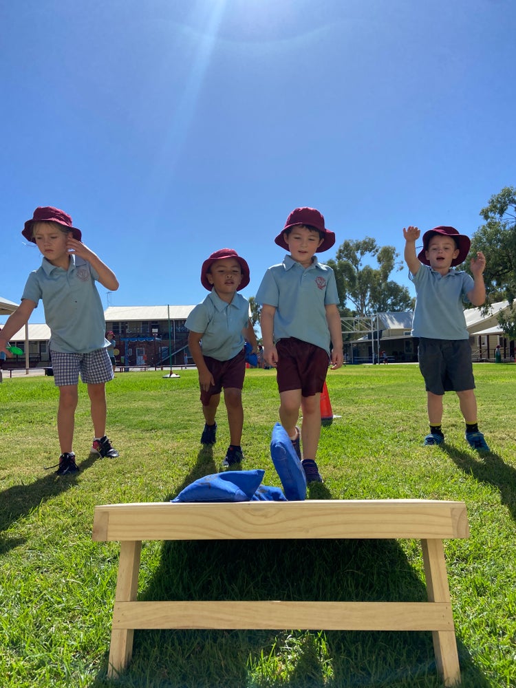 Four infants students playing corn hole