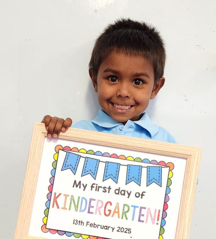 Kindergarten boy holding first day sign