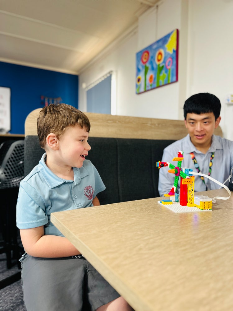 Boy and teacher building Lego STEM kit